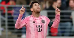 Piłkarz Lionel Messi w różowej koszulce Interu Miami, z uniesionymi palcami, jakby świętował kolejne bramki.