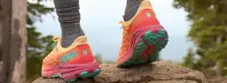 Kolorowe buty Hoka na kamienistym szlaku. Firma Hoka słynie z amortyzacji i innowacyjnych rozwiązań dla biegaczy.