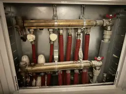 Rozdzielacz ogrzewania podłogowego z zaworami. Dowiedz się, jak zakręcić ogrzewanie podłogowe, zamykając dopływ wody.