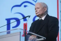 Jarosław Kaczyński przemawia na tle niebieskiego ekranu z logo PiS.
