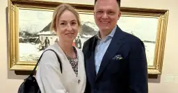 Para uśmiecha się na tle obrazu zimowego pejzażu.