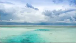 Malediwy w porze deszczowej: turkusowa woda i burzowe chmury nad oceanem.