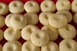 Ułożone rzędami jasne, okrągłe kluski śląskie z charakterystycznym wgłębieniem.