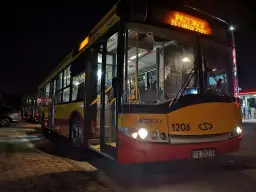 Autobus BP Tour z numerem 1206 na nocnym postoju, z zapalonymi światłami.