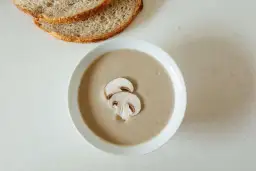 Kremowa zupa pieczarkowa z pieczywem. Jakie przyprawy do zupy pieczarkowej? Sól, pieprz, gałka muszkatołowa i tymianek podkreślą jej smak.