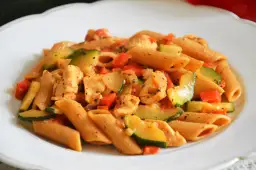 Penne z kurczakiem, cukinią i pomidorami w sosie. Pyszne dania z makaronem ryżowym i kurczakiem.
