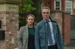 Para, z poważną miną, stoi obok kobiety. Słowa "zostan przy mnie" zdają się wisieć w powietrzu.