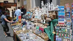 Stoisko z pamiątkami w Rzymie. Znajdziesz tu figurki, magnesy i książki. Idealne, co warto przywieźć z Włoch dla dzieci to małe repliki zabytków.