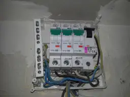 Widok z bliska na skrzynkę z bezpiecznikami i przewodami elektrycznymi.