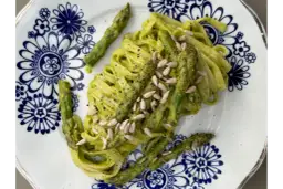 Makaron z zielonym pesto i szparagami, posypany pestkami słonecznika. Czy makaron jest zdrowy? Zależy od dodatków!