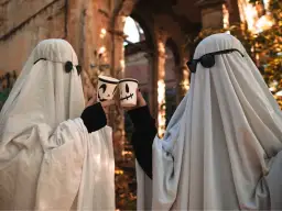 Dwa duchy w okularach przeciwsłonecznych wznoszą kubki z dyniami. Prosty strój, jak zrobić strój Hefajstosa, ale na Halloween!