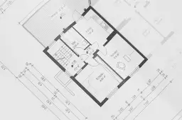 Plan architektoniczny domu z wymiarami, uwzględniający minimalną szerokość działki budowlanej. Widoczne pomieszczenia: kuchnia, łazienka, salon, sypialnia.