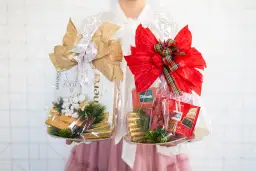 Dwa świąteczne kosze prezentowe: jeden ze złotymi dodatkami, drugi z czerwonymi. Idealne pomysły, co kupić rodzicom pod choinkę.