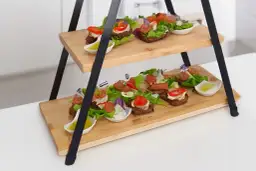 Elegancka patera na przekąski z dwoma poziomami, pełna kolorowych kanapeczek z warzywami i mięsem. Idealna na przyjęcie.