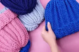 Różowe, błękitne i granatowe czapki z grubej włóczki. Dwie niebieskie czapki, jedna jasna, druga ciemna. Ile motków na czapkę?