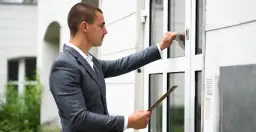 Mężczyzna w garniturze puka do drzwi, trzymając teczkę. Zastanawia się, ile czasu ma sąd na wysłanie pozwu do pozwanego.