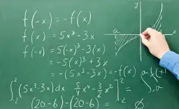 Rysunek na tablicy pokazuje obliczenia matematyczne, w tym całki i funkcje, ilustrujące, co to system zero jedynkowy a binarny.