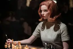 Beth Harmon, bohaterka "Gambitu królowej 2", skupiona nad szachownicą, przygotowuje się do kolejnego ruchu.