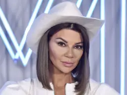 Edyta Górniak w białym kapeluszu kowbojskim, z makijażem i w białej kurtce. Zastanawiasz się, ile ma lat Edyta Górniak?