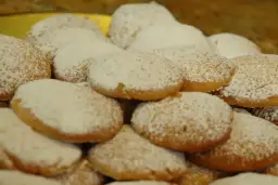 Stos ciasteczek oprószonych cukrem pudrem, idealnych do kawy. Ten przepis na ciastka jest prosty i szybki.