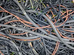 Plątanina kabli, w tym pomarańczowych i czarnych, może być myląca przy wyborze, jaki kabel do licznika 3 fazowego.