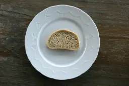 Jedna kromka chleba na białym talerzu. Zastanawiasz się, ile waży kromka chleba?