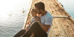 Ojciec tuli córkę na pomoście. Mimo rozstania, prawa ojca do dziecka bez ślubu są widoczne w tej czułej chwili.