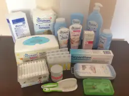 Zestaw kosmetyków dla noworodka: chusteczki, kremy, puder, płatki kosmetyczne, aspirator, grzebyk, nożyczki.