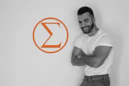 Uśmiechnięty mężczyzna z zarostem, w białej koszulce i jeansach, stoi obok pomarańczowego symbolu Sigma. Jego postawa emanuje pewnością siebie, odzwierciedlając cechy samca sigma.