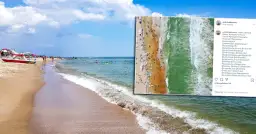 Plaża pełna ludzi, fale rozbijają się o brzeg. Czy Morze Czarne jest czyste? Woda wygląda na zieloną i przejrzystą.