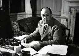 C.S. Lewis, autor "Opowieści z Narnii", siedzi przy biurku, otoczony papierami i atramentem.