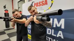 Dwóch mężczyzn ćwiczy celowanie z broni na kursie na ochroniarza.