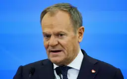 Donald Tusk, w garniturze i z serduszkiem na klapie, przemawia. Zastanawiamy się, co zrobił Tusk dla Polski.