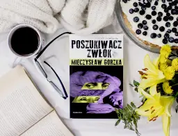 Recenzja książki "Poszukiwacz zwłok" Mieczysława Gorzki. Kawa, okulary, otwarty tom i ciasto z jagodami tworzą idealny nastrój do czytania.