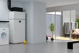 Nowoczesna pompa ciepła do domu 180m2 z grzejnikami, obok pralka i zabawki. Na zewnątrz widać taras z meblami.