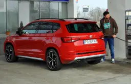 Mężczyzna tankuje czerwonego SUV-a. Zastanawiasz się, ile pali suv? Ten model Seat Ateca właśnie dostaje paliwo.
