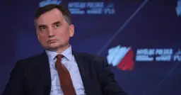 Zbigniew Ziobro w garniturze i krawacie, na tle logo "Myśl Polska".