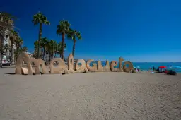 Piaskowy napis "Malagueta" na plaży, palmy i błękitne morze. Czy Malaga ma dostęp do morza? Tak, jak widać!