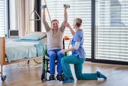 Starszy mężczyzna w wózku ćwiczy z hantlami pod okiem fizjoterapeutki. Czy rehabilitacje można odliczyć od podatku?
