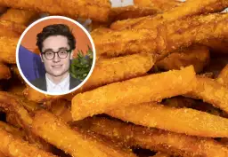 Młody mężczyzna w okularach uśmiecha się na tle chrupiących frytek z batata. Dowiedz się, jak pokroić batata na frytki!