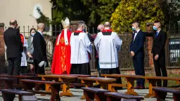 Biskup w czerwonej kapie i ministranci podczas ceremonii bierzmowania.