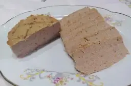 Pokrojony pasztet wieprzowy na talerzu z ozdobnym wzorem.