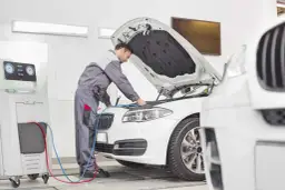 Mechanik sprawdza samochód, by dowiedzieć się, ile kosztuje przegląd rejestracyjny.