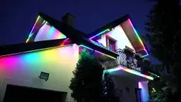 Kolorowe taśmy LED ozdabiają dach i balkon domu, tworząc magiczną atmosferę. Idealne, jakie ledy do pokoju, by rozświetlić noc.