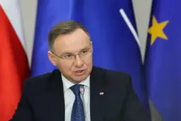 Andrzej Duda w garniturze, za nim flagi Polski i UE. Prawdziwe powody dla których Andrzej Duda zapowiedział serię wet do ustaw budżetowych.
