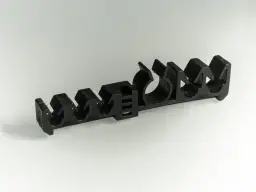 Czarny, plastikowy uchwyt z wieloma otworami, służący do mocowania przewodów hamulcowych.
