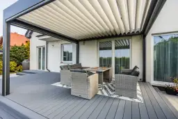 Nowoczesna pergola z meblami wypoczynkowymi na tarasie. Czy zabudowa tarasu wymaga pozwolenia na budowę?