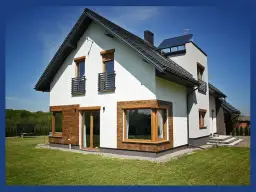 Nowoczesny dom z białym tynkiem, drewnianymi elementami i antracytowym dachem. Okna w kolorze winchester dodają elegancji.