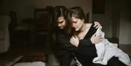 Dwie kobiety przytulają się, jedna pociesza drugą.