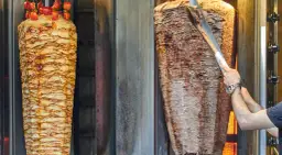 Dwa pionowe rożna z mięsem do kebaba, jeden z kurczakiem i pomidorkami, drugi z wołowiną. Zastanawiasz się, ile kebabów dziennie można sprzedać?